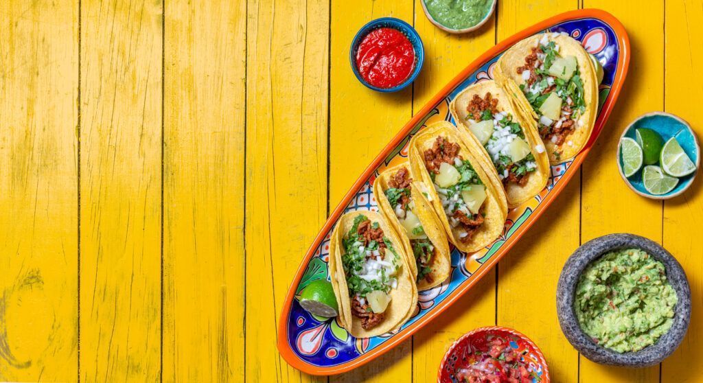 Mexican background with tacos al pastor and mexican sauces.